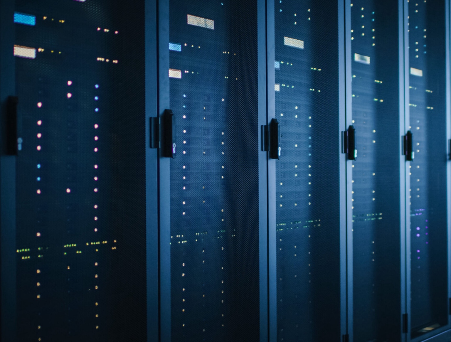 Row of server cabinets with illuminated status lights.