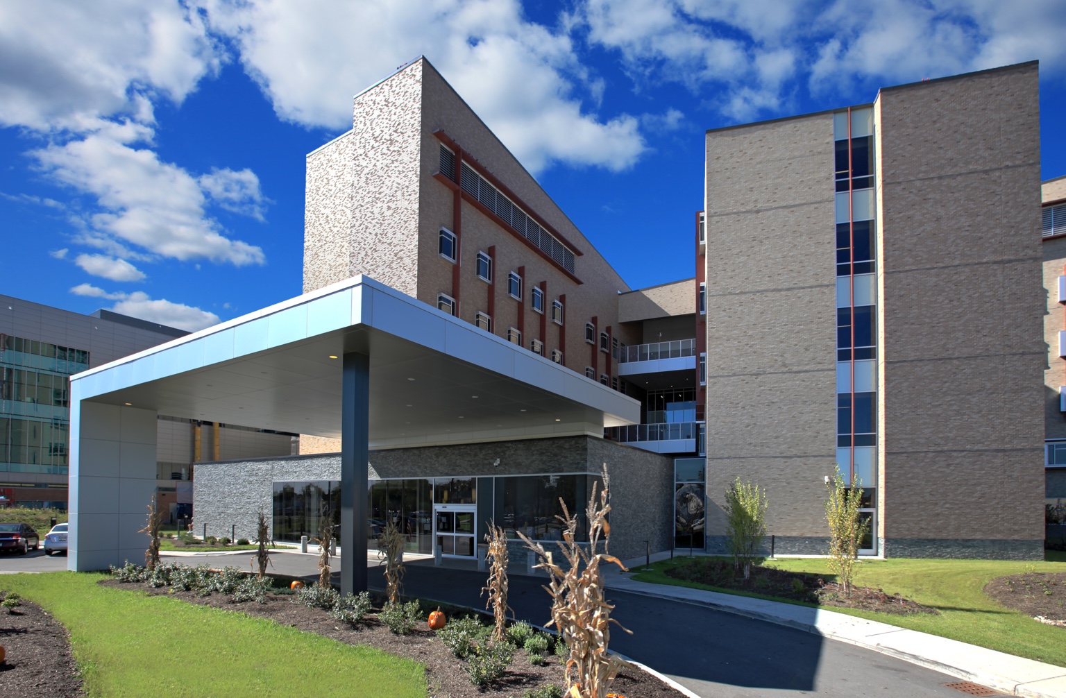 Brick building with a broad entrance canopy and landscaped grounds.